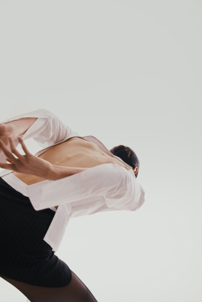 The shirt is white with an open back